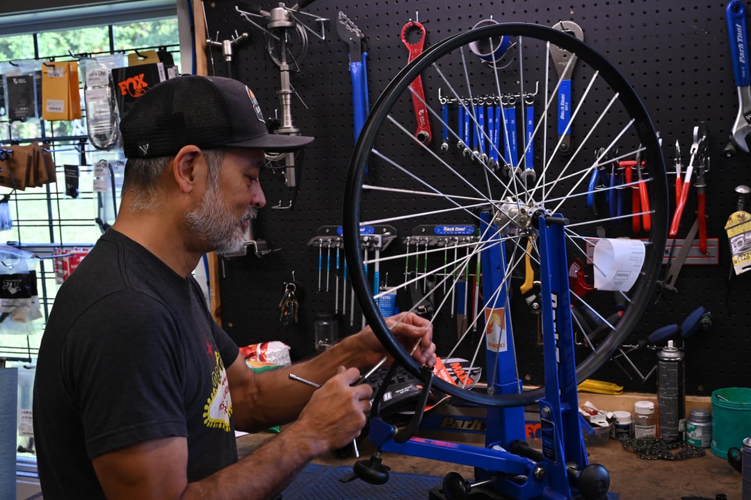 bike mechanic working on wheel